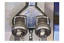 Zwei gekuppelte Auslässe einer Steigleitung zur Feuerwehr-Wasserversorgung aus Metall, mit Ketten gesichert.